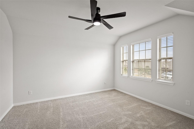 empty room featuring ceiling fan, lofted ceiling, and carpet