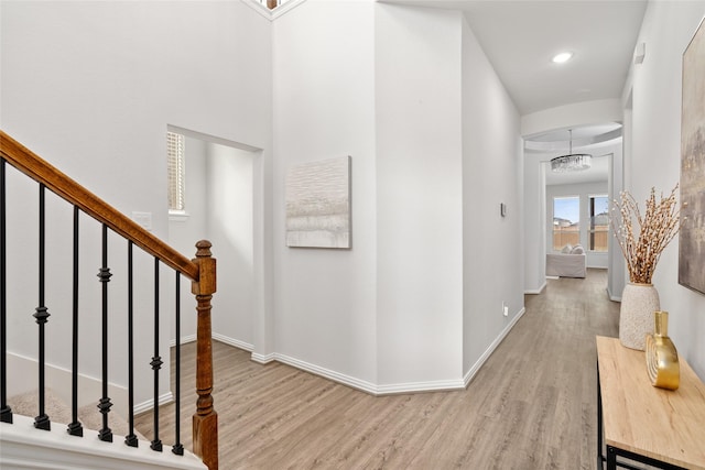 hallway with an inviting chandelier and hardwood / wood-style floors