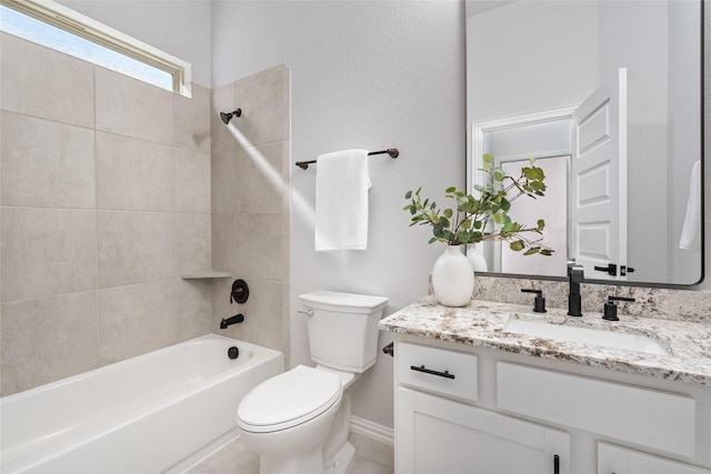 full bathroom featuring tiled shower / bath, vanity, and toilet