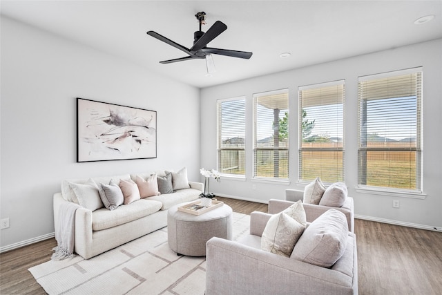 living room featuring light hardwood / wood-style flooring and ceiling fan