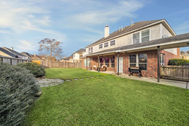 back of house with a patio area and a lawn