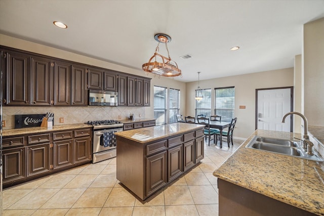 kitchen with stainless steel range with gas cooktop, sink, a center island, and dark brown cabinets