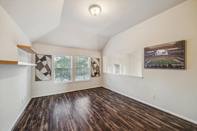 unfurnished room featuring vaulted ceiling and dark wood-type flooring