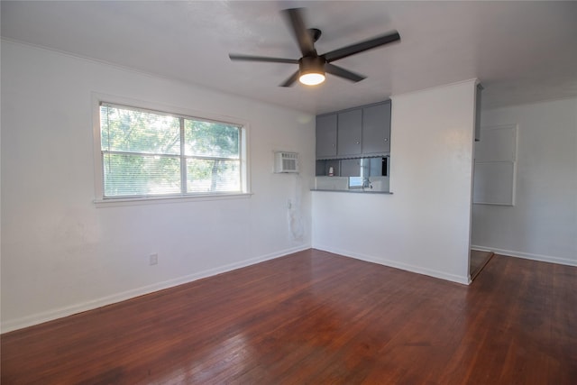 2713 John St, La Marque, TX 77568 - unfurnished living room with dark wood-type flooring, baseboards, ceiling fan, and a wall unit AC