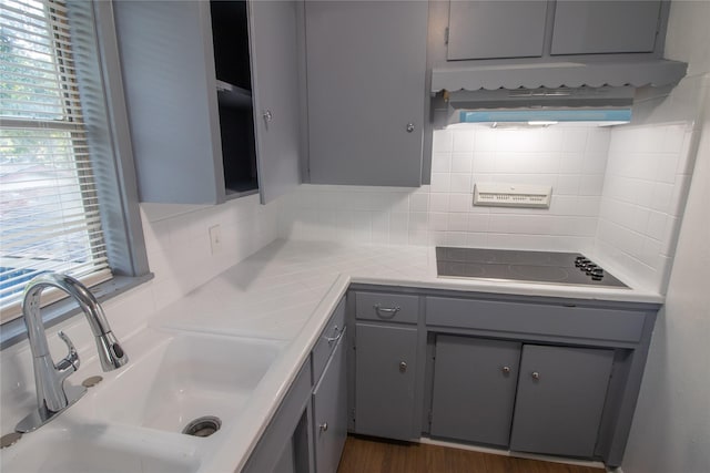 2713 John St, La Marque, TX 77568 - kitchen with a sink, gray cabinets, backsplash, and black electric cooktop