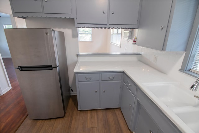 2713 John St, La Marque, TX 77568 - kitchen with dark wood-type flooring, freestanding refrigerator, gray cabinets, and light countertops