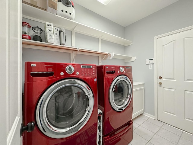 clothes washing area with cabinets, washing machine and dryer, and light tile patterned flooring