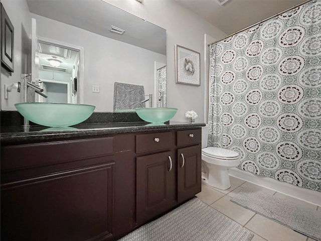 bathroom with tile patterned flooring, vanity, walk in shower, and toilet