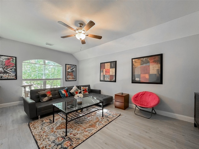 living room featuring ceiling fan, lofted ceiling, and light hardwood / wood-style floors