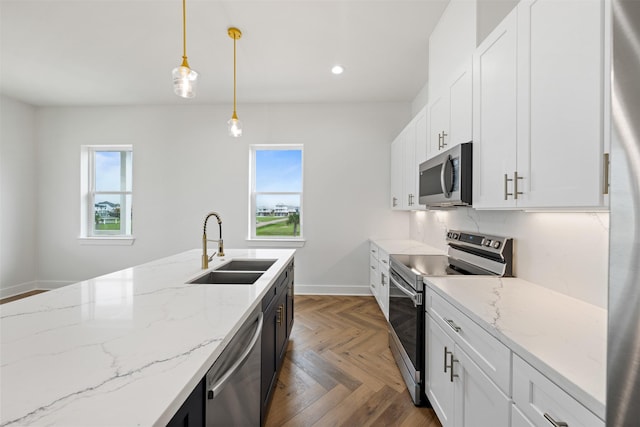 kitchen with pendant lighting, sink, stainless steel appliances, and white cabinets