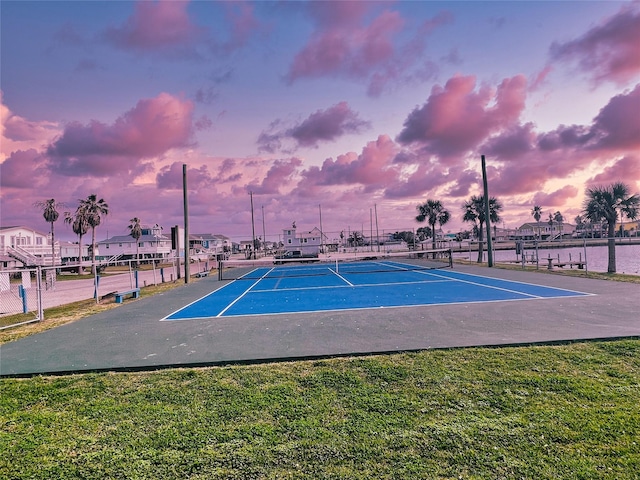 view of tennis court featuring a water view