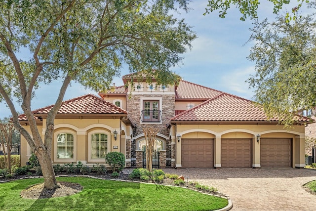 mediterranean / spanish house with a garage and a front lawn