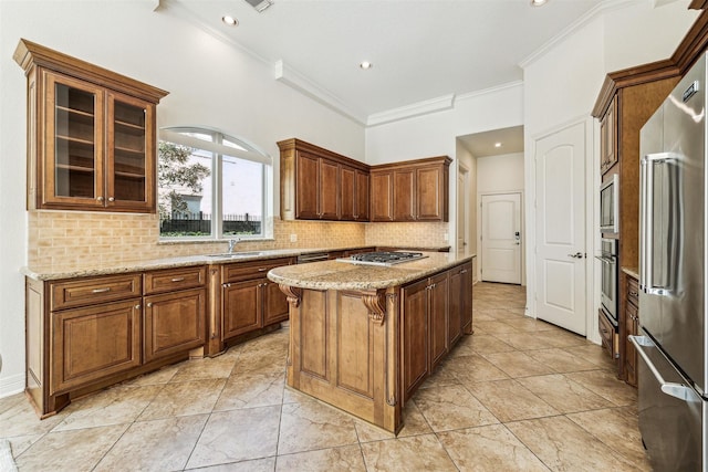 kitchen with sink, decorative backsplash, a center island, stainless steel appliances, and light stone countertops