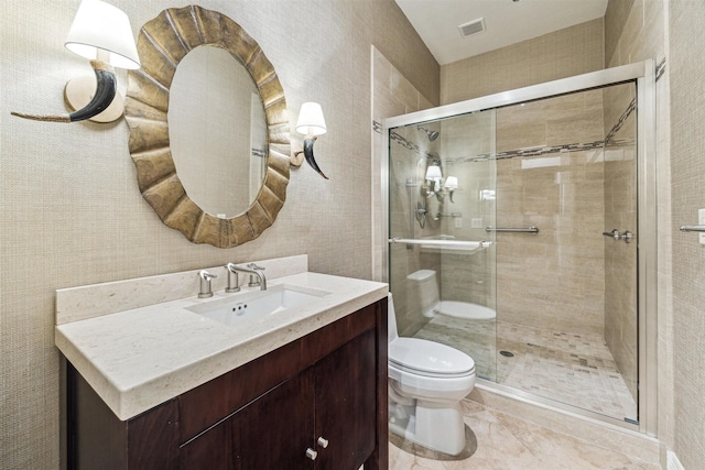 bathroom featuring vanity, toilet, and a shower with shower door