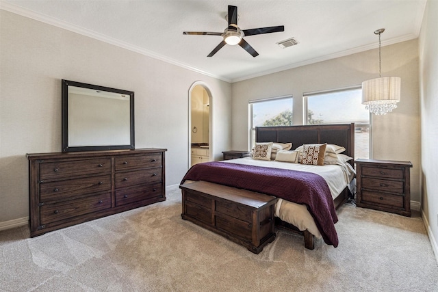 bedroom featuring ornamental molding, ceiling fan with notable chandelier, light colored carpet, and ensuite bath