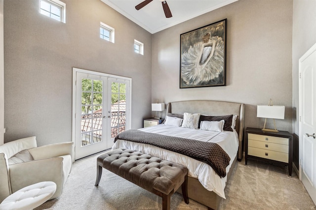 bedroom with a towering ceiling, ornamental molding, access to outside, light colored carpet, and french doors