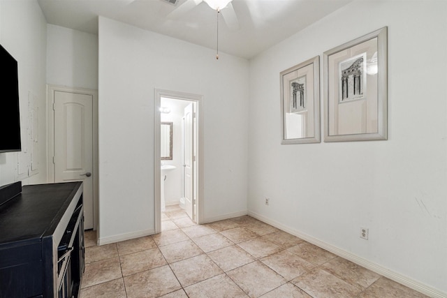 interior space featuring connected bathroom and light tile patterned flooring