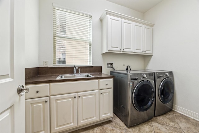 washroom with cabinets, washing machine and dryer, and sink