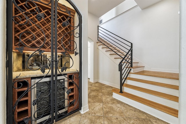 wine area featuring tile patterned floors and bar