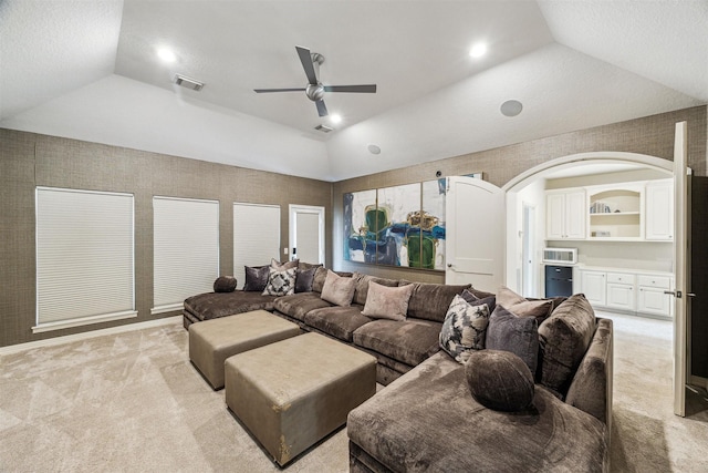 carpeted living room featuring ceiling fan, lofted ceiling, and a raised ceiling