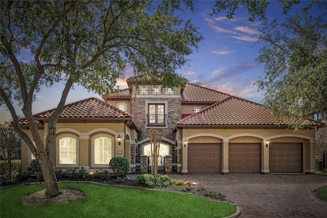 mediterranean / spanish house featuring a garage and a yard