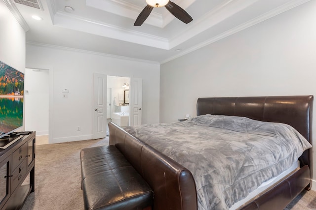 carpeted bedroom featuring ceiling fan, ornamental molding, a tray ceiling, and connected bathroom