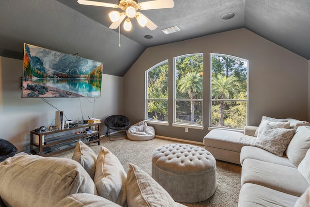 living room featuring ceiling fan, lofted ceiling, carpet flooring, and a textured ceiling