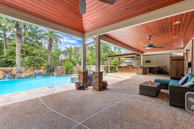 view of swimming pool with pool water feature, ceiling fan, an outdoor living space, and an outdoor bar