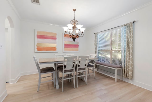 dining room with crown molding, a chandelier, and light hardwood / wood-style floors