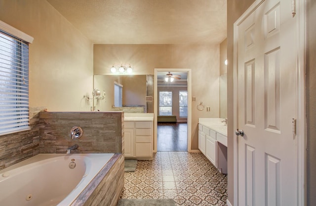 bathroom featuring vanity, tiled tub, tile patterned flooring, and ceiling fan