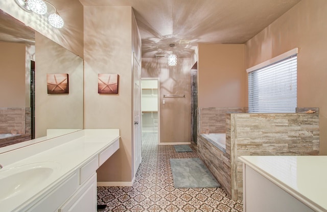 bathroom featuring tiled tub, vanity, and tile patterned floors