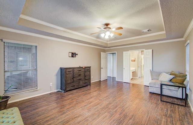 living area featuring a raised ceiling, ceiling fan, hardwood / wood-style floors, and a textured ceiling