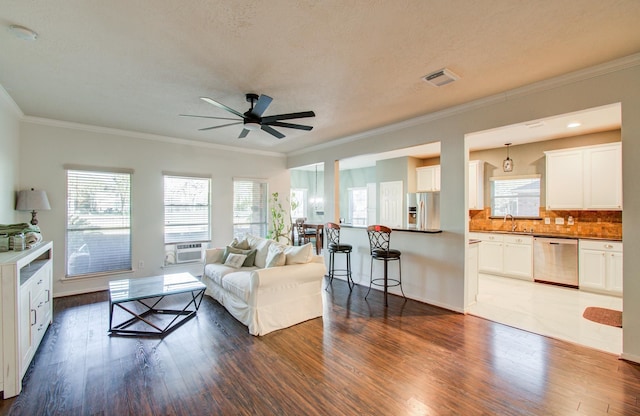 living room with dark wood-type flooring, ceiling fan, ornamental molding, and sink