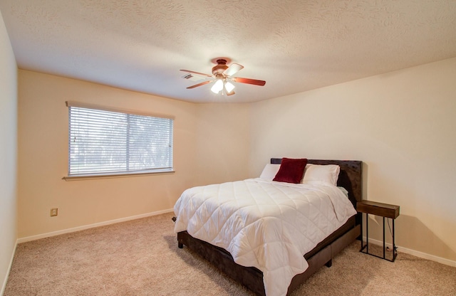 carpeted bedroom with ceiling fan and a textured ceiling