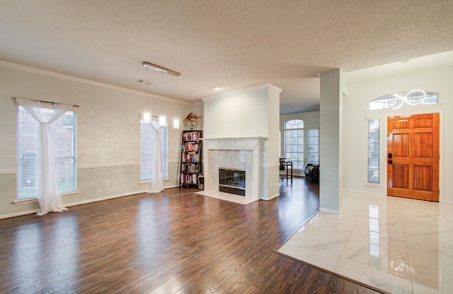 unfurnished living room featuring crown molding, hardwood / wood-style flooring, a fireplace, and a textured ceiling