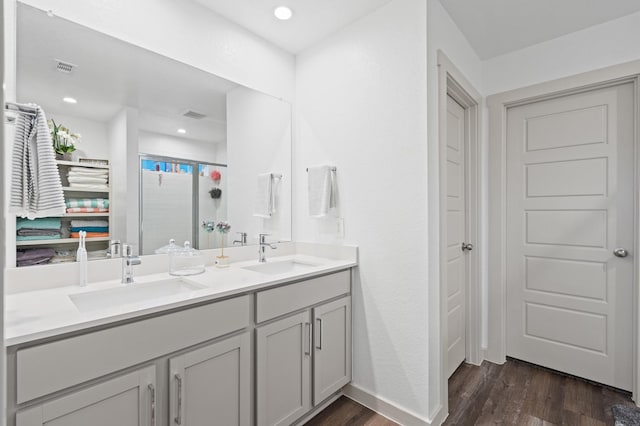 bathroom with walk in shower, wood-type flooring, and vanity