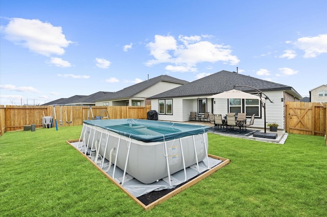 back of property featuring a yard and a covered pool