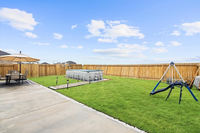 view of yard featuring a playground, a patio, and a covered pool