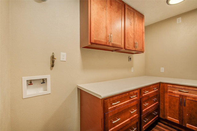 washroom featuring hookup for a washing machine and cabinets