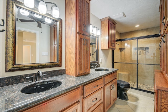 bathroom with tile patterned floors, toilet, a shower with shower door, a textured ceiling, and vanity