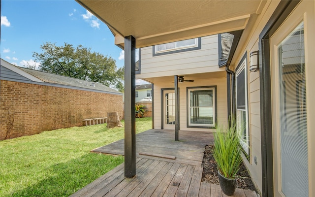 wooden terrace with ceiling fan and a lawn