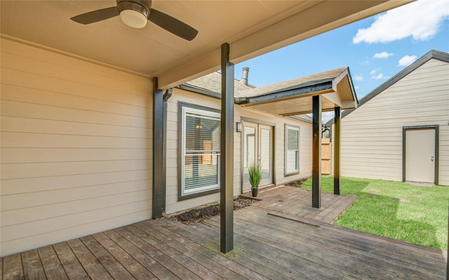 wooden terrace featuring ceiling fan and a lawn