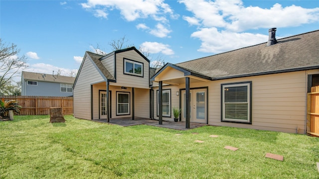 back of property with a yard and a patio area