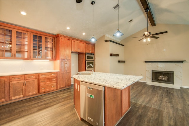 kitchen featuring appliances with stainless steel finishes, pendant lighting, an island with sink, dark hardwood / wood-style flooring, and light stone counters