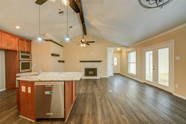 kitchen featuring appliances with stainless steel finishes, dark hardwood / wood-style floors, lofted ceiling with beams, hanging light fixtures, and light stone counters