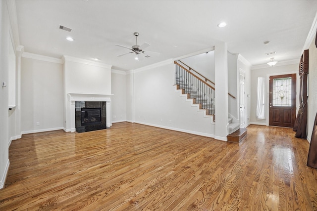 unfurnished living room with ornamental molding, ceiling fan, a fireplace, and light hardwood / wood-style floors