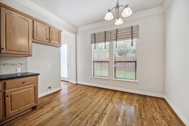 kitchen featuring backsplash, wood-type flooring, and ornamental molding