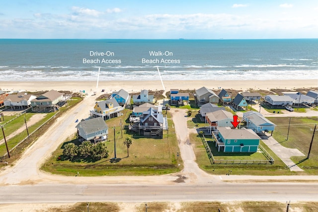 drone / aerial view with a residential view, a view of the beach, and a water view