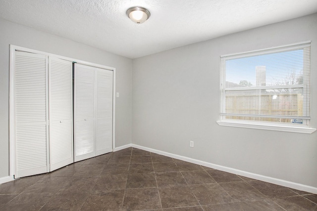 unfurnished bedroom with a textured ceiling and a closet