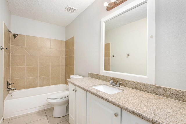 full bathroom featuring tile patterned floors, toilet, a textured ceiling, vanity, and tiled shower / bath combo